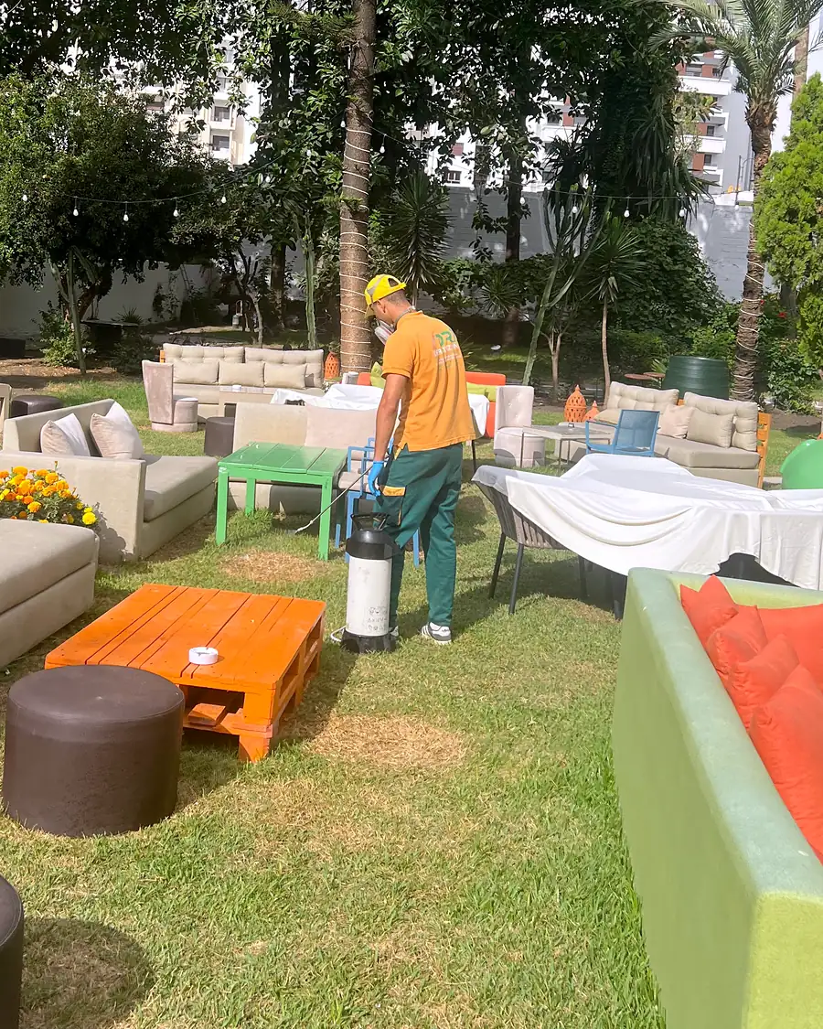 Un technicien Deratizon traite le jardin et la terrasse d’un restaurant.